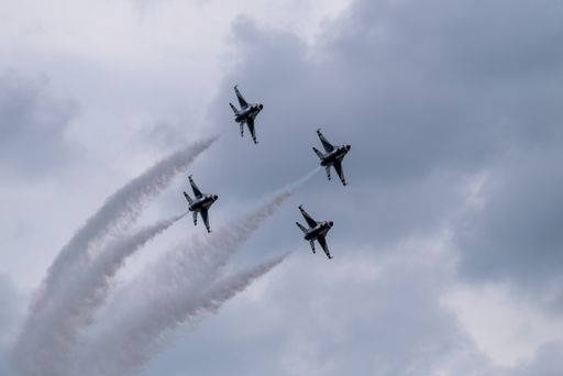 A group of flying aircraft against a cloudy sky during the National Air Show in Cleveland, USA