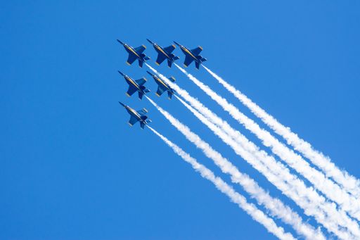A group of flying aircrafts against a blue sky during an airshow