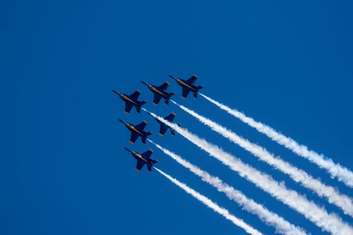 A group of flying aircrafts against a blue sky during an airshow