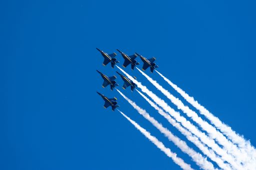 A group of flying aircrafts against a blue sky during an airshow