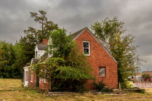 An abandoned old brick house on the grassy field