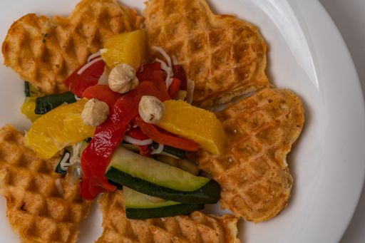vegan waffles with fruit, vegetables and almond flour batter on a white background.