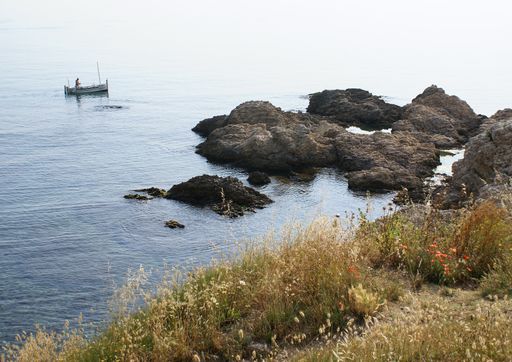 A beautiful view of a small boat near the coast on a gloomy day