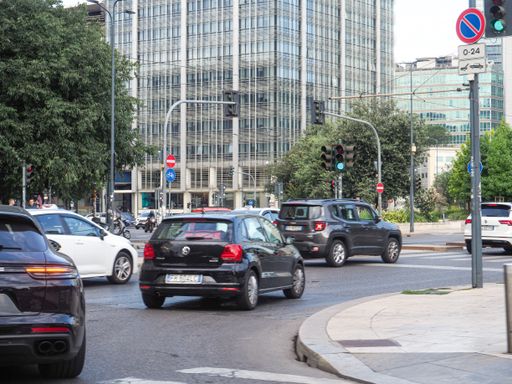 The cars moving in the busy street of the city of Milan in Italy