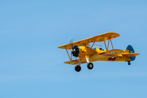 A flying vintage aircraft against a blue sky during an airshow