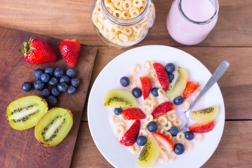 A closeup shot of a bowl full of yogurt decorated with some berries on top