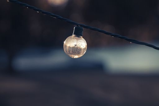 A selective focus shot of a turned-off lightbulb on a string