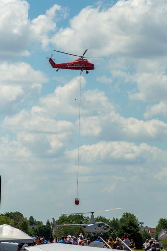 A flying red rescue helicopter against a cloudy sky