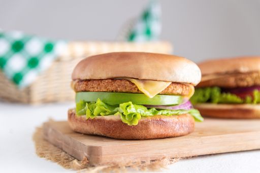 A closeup shot of hamburgers on a wooden cutting desk