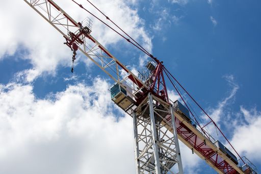 A low angle shot of a construction crane under the daylight sky