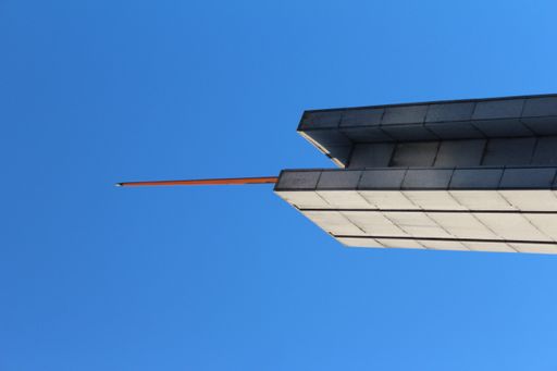 A vertical low angle closeup of an architectural brick tower under a clear sky
