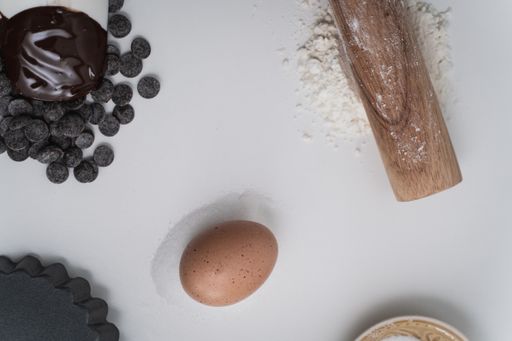 A top view of wooden rolling pin and flour on a table for baking cookies