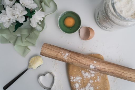 A top view of wooden rolling pin and flour on a table for baking