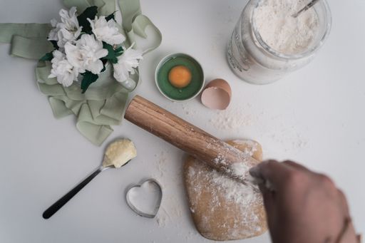A top view of wooden rolling pin and flour on a table for baking