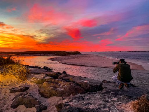 A photographer taking a picture of a lake during the sunset, United States