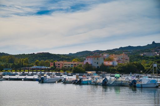 A beach full of boats and ships and the city Porto Cervo, Italy
