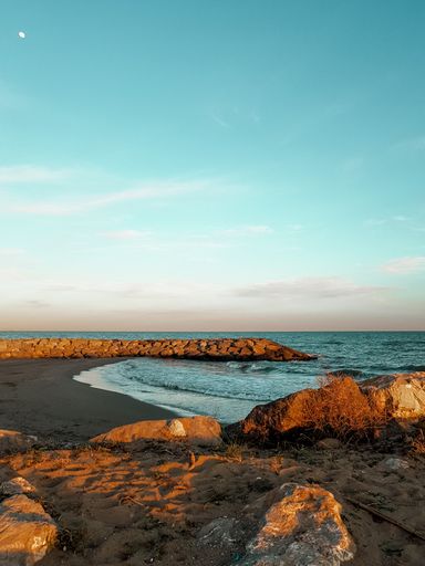 A beautiful view of the wavy sea hitting the sandy bea