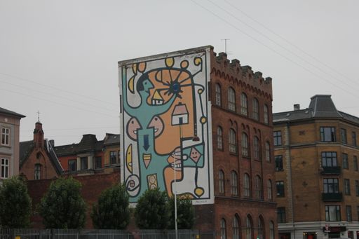 A beautiful view of a graffiti on the side of an old building against a sky in Copenhagen, Denmark
