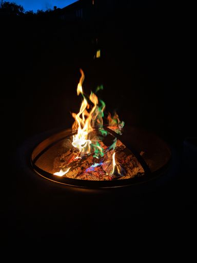 A selective of a fireplace in the dark forest