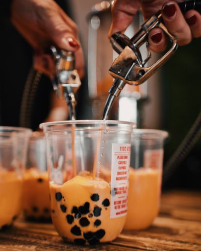 A closeup shot of a person pouring liquid into a container to make tasty coffee