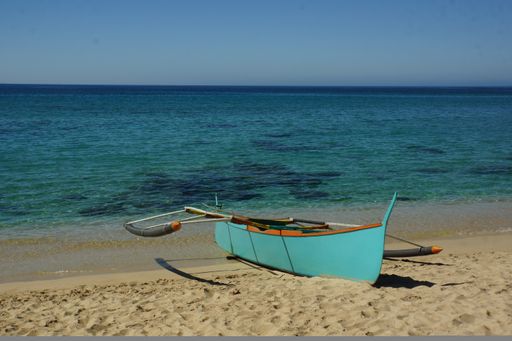 A beautiful view of a small boat on the beach under a clear sky
