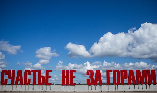 A red sign about happiness in Russian on the beach