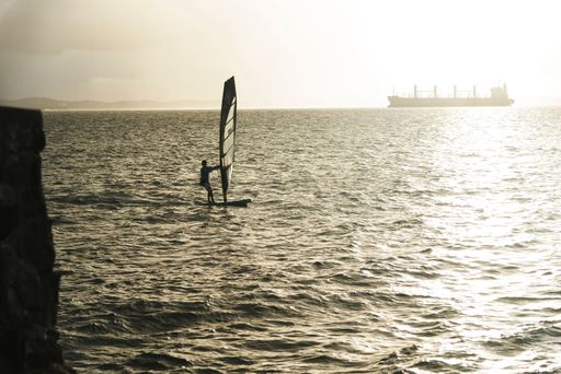 Sail boat sailing on the beautiful beach of Ribeira on a sunny day. Salvador, Bahia, Brazil.