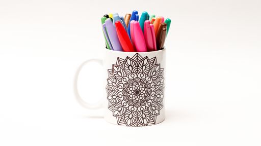 A set of colorful pens in a cup isolated on white background