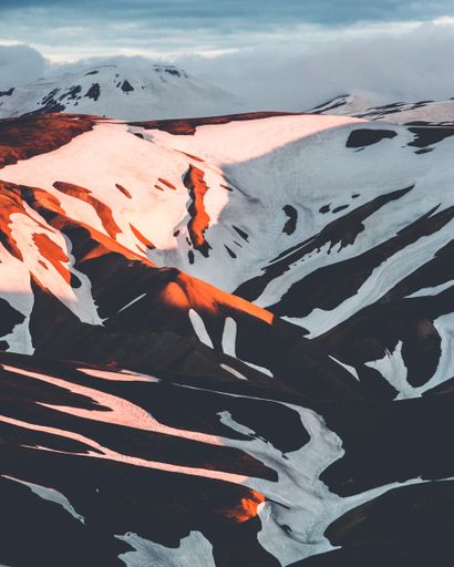 A vertical shot of beautiful snowy hills in Iceland countryside at sunset