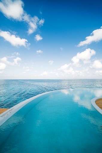 A vertical shot of the beautiful blue sky and the pool with the sea. The Maldives.