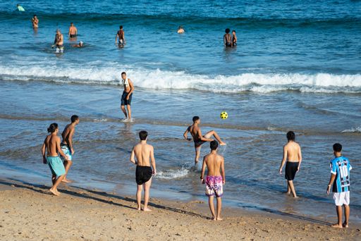 A group of young people playing beach soccer at Farol da Barra beach, Salvador, Brazil