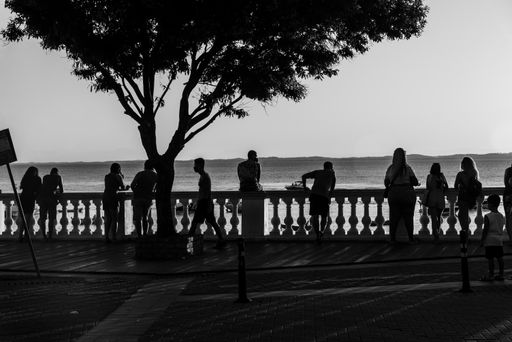 Silhouette of groups of people enjoying the beautiful sunset in Salvador at Porto da Barra beach. Well known and sought after tourist site.