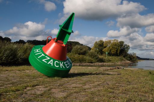 A maritime buoy near German city Hitzacker with the name of the city, river Elbe in the background