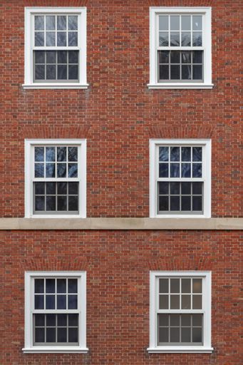 A vertical shot of a brick building with six windows