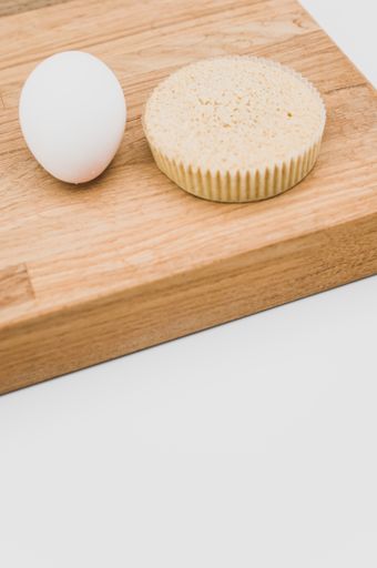 buckwheat flour and almonds organic cake and one egg on a wooden and white background with copy space
