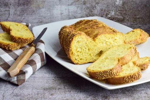 A closeup shot of a bread with sesame, a knife, and a towel