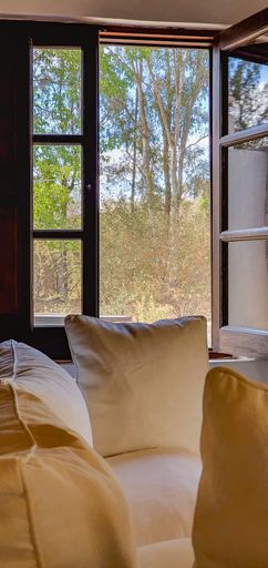 A vertical shot of a minimalistic bedroom with a door leading to the balcony