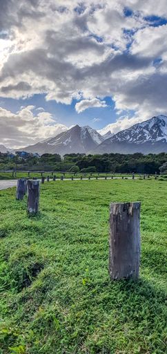 The cloudy sky over the mountains captured from the field in spring