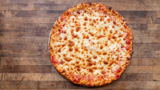 A fresh baked cheese pizza sits atop a decorative wooden cutting board with negative space.