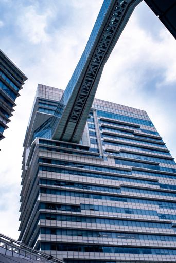 A low angle vertical shot of a modern building connected to other building with a bridge