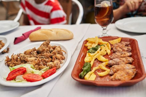 The grilled and fried chicken meat with french fries and vegetables
