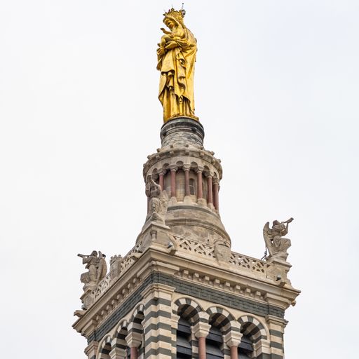 A vertical shot of the Virgin Mary statue on the bell tower of Notre dame de la Garde basilica