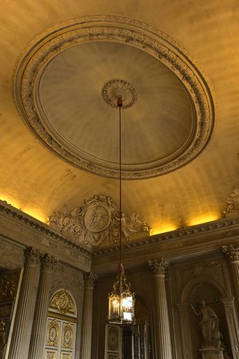 A low angle shot of chandelier and roof carvings to Palace of Versailles in France