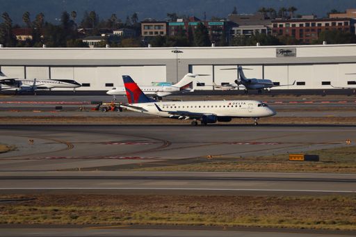Delta Connections Embraer E175 landing at SJC with Santa Cruz mountains in the background.