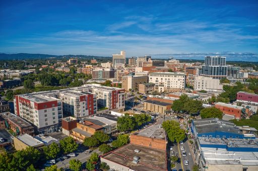 An aerial view of Greenville with dense buildings under a blue sky in South Carolina