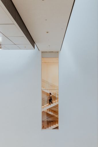 A vertical shot of the staircase seen from outside with a person of Museum of Modern Art in New York