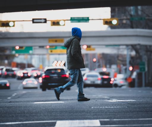 A male crossing the street in the city , Canada