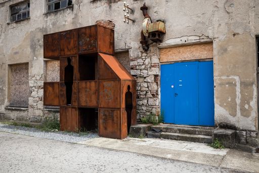 A rusty metal structure next to a blue door in Labin, Istria, Croatia