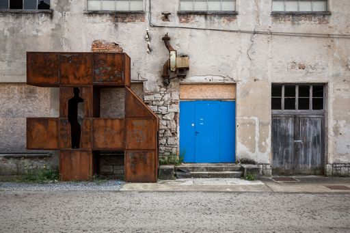 A rusty metal structure next to a blue door in Labin, Istria, Croatia