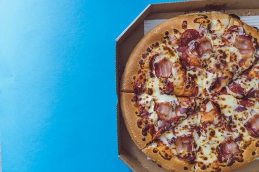 Top down view of american take away pizza ready for eating. Unhealthy nutrition concept with delivery pizza.  Fresh cheese, bacon and pepperoni.